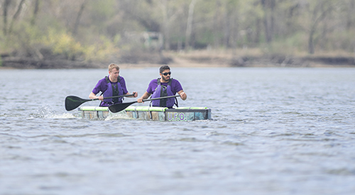 Two students paddle in a concrete canoe on Tuttle Creek Lake. 